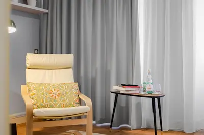 a chair sitting next to a table with a side table with a side tablength at Bohemia Boutique Hotel Prague in Prague