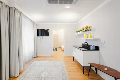 a white living room with a desk and a window at Bohemia Boutique Hotel Prague in Prague