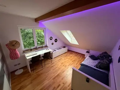 a bedroom with a bed and a desk and a window at Apartmán Břevnov in Prague