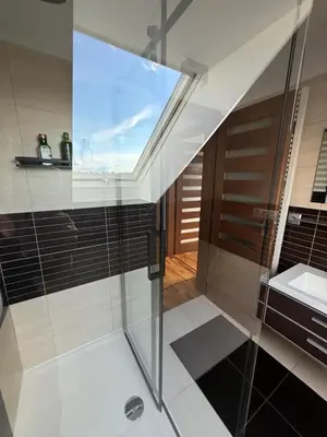 a bathroom with a glass shower and a sink at Apartmán Břevnov in Prague