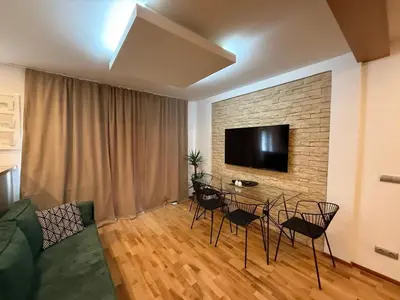 a living room with a table and chairs and a tv at Apartmán Břevnov in Prague