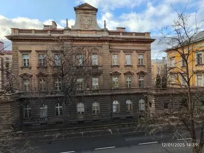 a large brick building with a clock tower on top at Alphonse Mucha Loft Apartments, Prague 2 in Prague