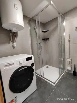 a washing machine in a bathroom with a shower at Alphonse Mucha Loft Apartments, Prague 2 in Prague
