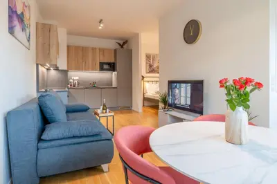 a living room with a blue couch and a table at William's Modern Luxe Suite by the Station in Prague