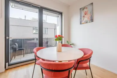 a dining room with a table and chairs and a window at William's Modern Luxe Suite by the Station in Prague