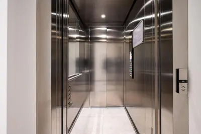 a hallway with a metal elevator in a building at William's Modern Luxe Suite by the Station in Prague