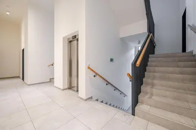 a hallway with stairs in a building at William's Modern Luxe Suite by the Station in Prague