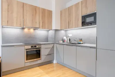 a kitchen with white cabinets and stainless steel appliances at William's Modern Luxe Suite by the Station in Prague