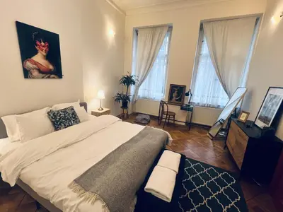 a bedroom with a large bed and two windows at Three Bedroom Apartment near Riegrovy Sady in Prague