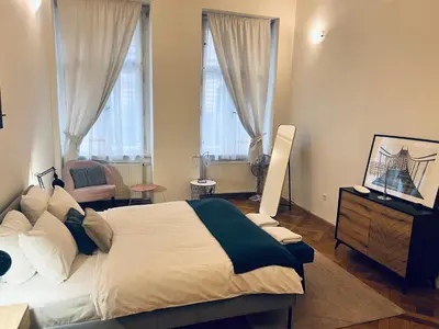 a bedroom with a large bed and two windows at Three Bedroom Apartment near Riegrovy Sady in Prague