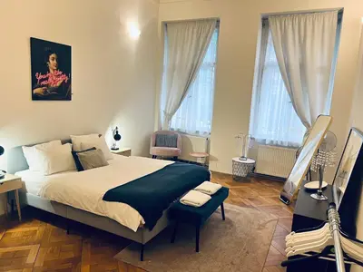 a bedroom with a large bed and two windows at Three Bedroom Apartment near Riegrovy Sady in Prague