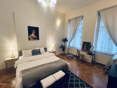 a bedroom with a large bed and two windows at Three Bedroom Apartment near Riegrovy Sady in Prague