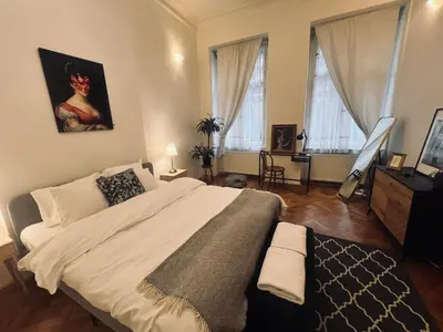 a bedroom with a large bed and two windows at Three Bedroom Apartment near Riegrovy Sady in Prague