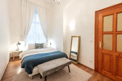 a bedroom with a bed and a mirror and a window at Three Bedroom Apartment near Riegrovy Sady in Prague