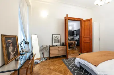 a bedroom with a bed and a desk with a mirror at Three Bedroom Apartment near Riegrovy Sady in Prague