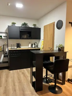 a kitchen with a table and a black counter top at Adel in Prague in Prague