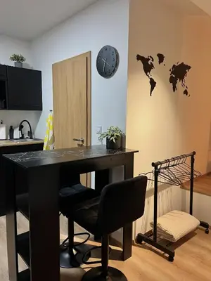 a desk with a chair and a clock on a wall at Adel in Prague in Prague