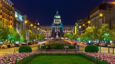 a large building with a clock tower at night at Royal Center Palace in Prague