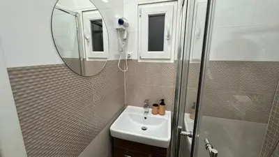 a bathroom with a sink and a shower and a mirror at Stylish Apartment by Charles Bridge in Prague