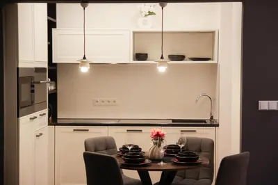 a kitchen with a table and chairs and a kitchen with white cabinets at Stylish Apartment by Charles Bridge in Prague