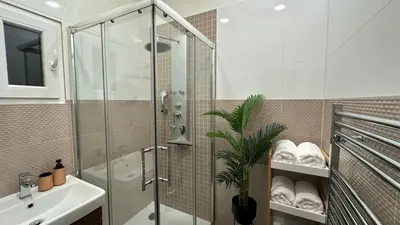 a bathroom with a glass shower and a sink at Stylish Apartment by Charles Bridge in Prague