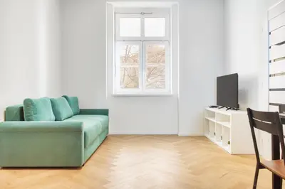 a living room with a green couch and a window at Modern City Apartment with Balcony by Rentez in Prague