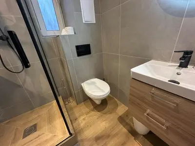 a bathroom with a toilet and a sink and a shower at Modern City Apartment with Balcony by Rentez in Prague