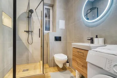 a bathroom with a shower and a toilet and a sink at Modern City Apartment with Balcony by Rentez in Prague