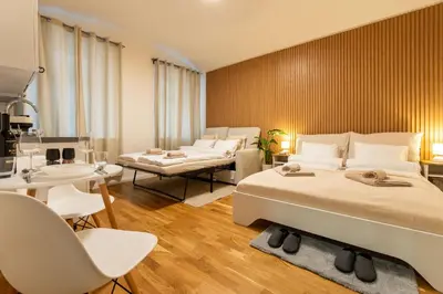 a bedroom with two beds and a table and chairs at ZEN APT Prague 1 City Center Modern Studio in Prague