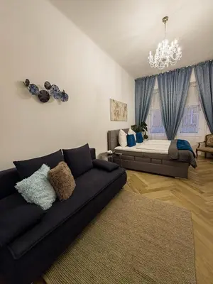 a living room with a couch and a bed at Rose Essence Suite in Prague
