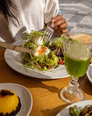 a person eating a plate of food with a salad at Old Royal Post Boutique Hotel & Premium Suites in Prague