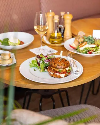 a table with plates of food and a sandwich on it at Old Royal Post Boutique Hotel & Premium Suites in Prague