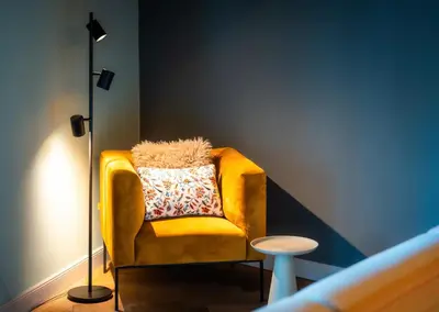 a yellow chair in a room with a lamp at Old Royal Post Boutique Hotel & Premium Suites in Prague