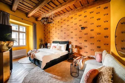 a bedroom with two beds and a couch at Old Royal Post Boutique Hotel & Premium Suites in Prague