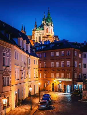 a city at night with a building with a clock tower at Old Royal Post Boutique Hotel & Premium Suites in Prague