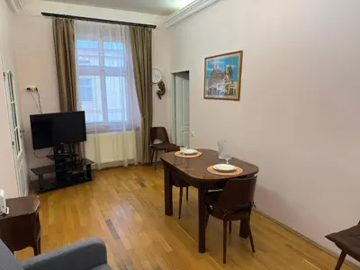 a living room with a table and a tv at Vintage Charm in the Heart of Prague in Prague