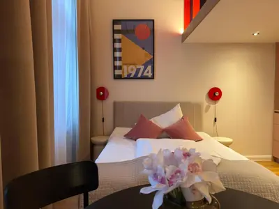 a bedroom with a bed with a table with flowers on it at Heritage Haven Mezzanine Apartment with Balcony in Prague