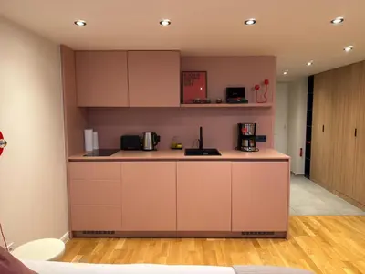 a kitchen with white cabinets and a counter top at Heritage Haven Mezzanine Apartment with Balcony in Prague