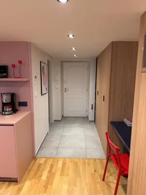 a hallway with a red chair and a white door at Heritage Haven Mezzanine Apartment with Balcony in Prague