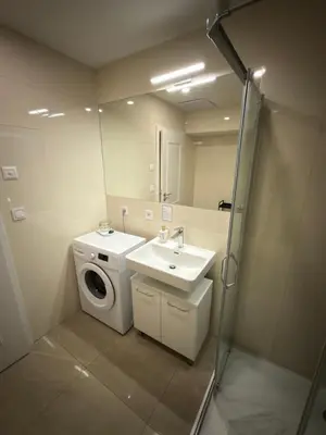 a bathroom with a washing machine and a sink at Heritage Haven Mezzanine Apartment with Balcony in Prague