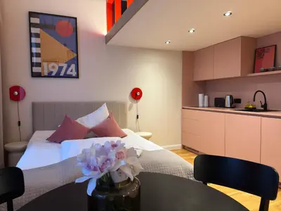 a bedroom with a bed and a table with flowers on it at Heritage Haven Mezzanine Apartment with Balcony in Prague