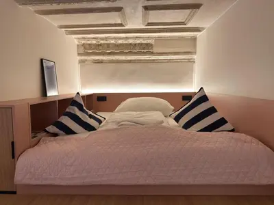 a bed with blue and white pillows in a room at Heritage Haven Mezzanine Apartment with Balcony in Prague