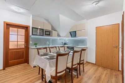 a kitchen and dining room with a table and chairs at The Dante House Šeberov in Prague