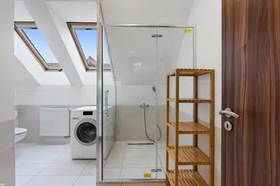 a bathroom with a washing machine and a washer at The Dante House Šeberov in Prague
