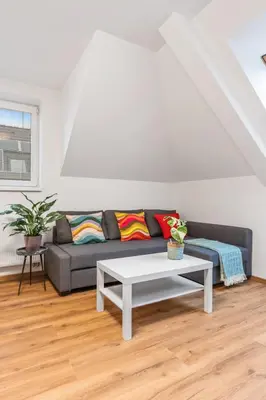 a living room with a couch and a table at The Dante House Šeberov in Prague