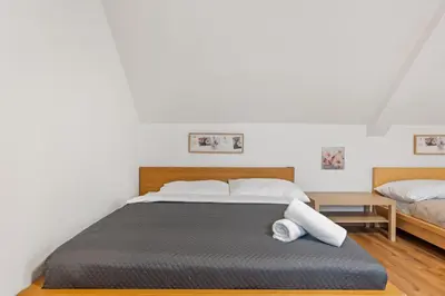 a bedroom with a bed and a table with two beds at The Dante House Šeberov in Prague