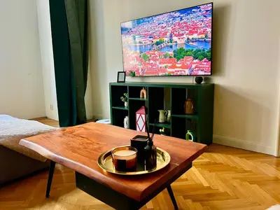 a living room with a coffee table and a tv at Elegant & inviting entire flat on Letná in Prague