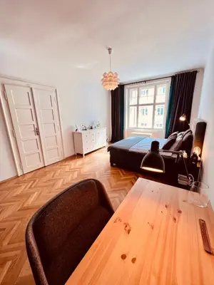 a bedroom with a bed and a table in it at Elegant & inviting entire flat on Letná in Prague