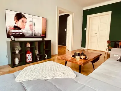 a living room with a couch and a tv at Elegant & inviting entire flat on Letná in Prague