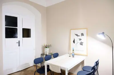 a dining room with a white table and blue chairs at Old Town - 2BR - Living Room - Sleeps 8 - Metro 1 minute - Newly renovated in Prague